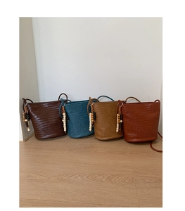 Detail of hand-woven bucket bags in four colors with wooden bead tassel ornaments