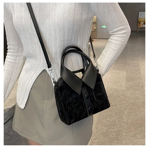 Close-up of a creative black velvet suit-collar handbag with decorative buttons