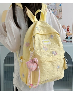 Quilted star backpack in yellow showing stylish star embroidery and plush heart charm