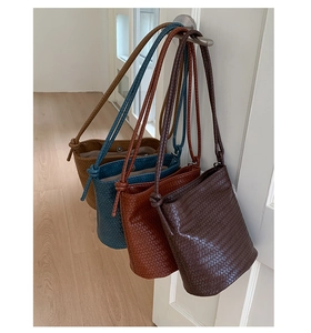 Detail of four woven bucket bags in various colors featuring metal magnetic closures