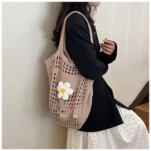 Détail du sac cabas au crochet beige fait main avec une décoration florale de marguerite 3D