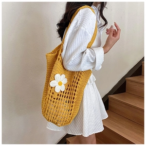 Gros plan sur un sac fourre-tout en tricot jaune avec marguerite et détails ajourés