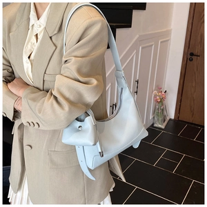 Close-up of light blue baguette bag with litchi texture and matching mini coin purse