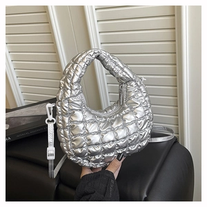 Close-up of metallic silver quilted dumpling bag with adjustable shoulder strap