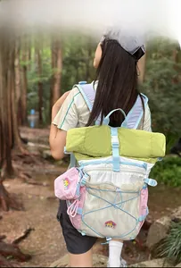 Outdoor backpack with color-blocking design and bungee system worn in nature