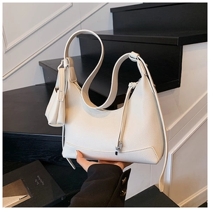 Detail of white lychee grain leather hobo bag with matching mini pouch and slim strap
