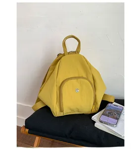 Detailed view of ginger yellow waterproof nylon multifunctional backpack and front zipper pocket