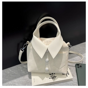 Detailed view of cream crossbody bag featuring creative shirt-style design and silver hardware