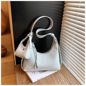 Detail of light blue lychee pattern leather hobo bag with mini pouch on wooden surface
