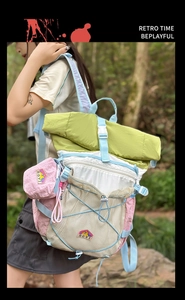 Detail view of colorful outdoor nylon backpack with roll-top closure and bungee cord system