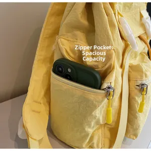 Détail de la poche latérale zippée d'un sac à dos de voyage en nylon jaune pour téléphone