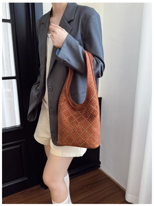 Dettaglio borsa tote in pelle scamosciata marrone con borchie e trama trapuntata classica