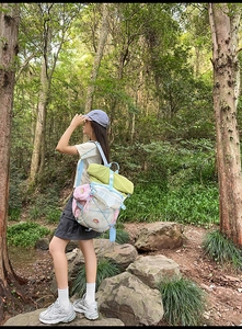 Outdoor hiking backpack with vibrant color-blocking design shown in a lush forest setting