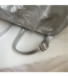 Detailed macro view of the silver metallic shoulder strap with an adjustable metal buckle