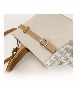 Détail de la texture tissée, sangle en cuir et foulard pied-de-poule sur sac crème chic