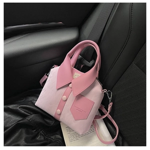 Pink shirt-shaped handbag with buttons and collar on a car seat next to a book