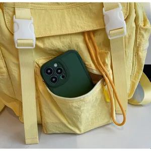 Détail de la grande poche zippée avant sur un sac à dos en nylon jaune imperméable