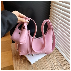 Detailed macro view of pink litchi grain leather hobo bag and matching coin purse