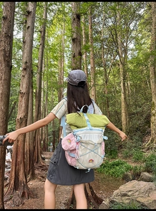 Detail of color-block outdoor backpack with elastic mesh pocket and roll-top closure