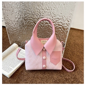 Detail of pink shirt-shaped handbag showing decorative buttons and leather texture