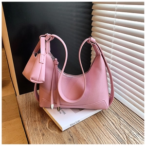 Detail of pink hobo bag with pebble leather texture and a matching mini coin purse charm