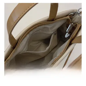 Vue intérieure du sac seau beige avec doublure à chevrons et une poche à fermeture éclair