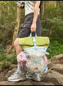 Detail of color-block outdoor backpack with roll-top closure and bungee cord storage