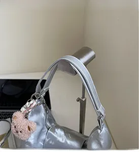 Detail of durable silver tote handle with pink bear charm and silk scarf decoration