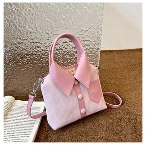 Detail of pink shirt-shaped handbag featuring 3D collar buttons and leather texture