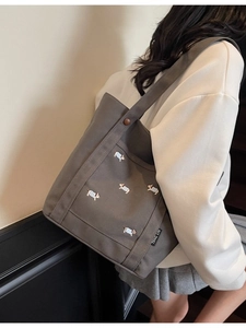 Sac fourre-tout en toile taupe avec broderie de corgis porté à l'épaule pour le style