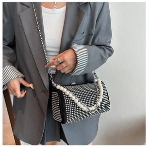 Detailed close-up of sparkling black rhinestone Boston bag with elegant pearl chain handle
