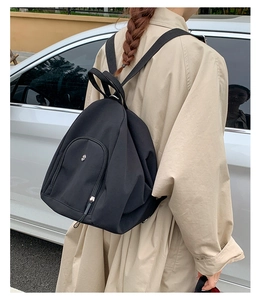 Outdoor shot of a black multifunctional backpack with large capacity and nylon waterproof fabric