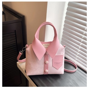 Detail shot of a creative light pink shirt-styled handbag with collar and buttons