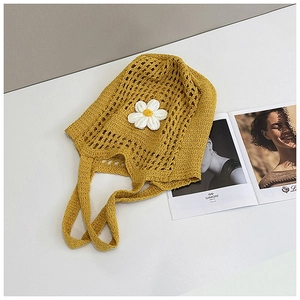 Détail d'un sac cabas en tricot jaune avec applique marguerite blanche et maille ajourée