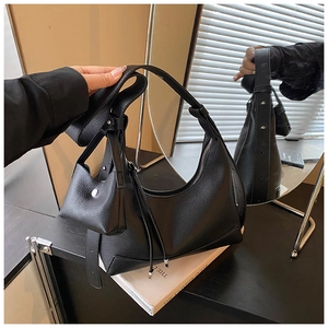 Detail of black lychee grain leather crescent bag with adjustable strap and mini pouch