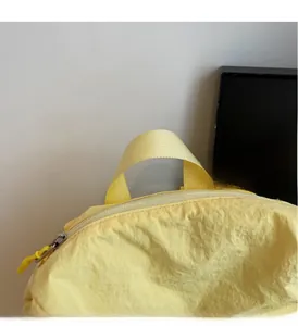 Détail des poignées tissées solides et de la fermeture éclair sur sac à dos jaune