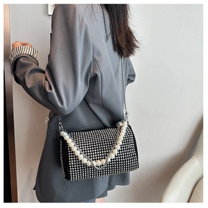 Detail of black velvet Boston bag featuring shimmering rhinestones and pearl chain handle