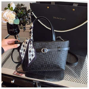 Détail du sac à main noir texturé avec foulard pied-de-poule et boucle métallique