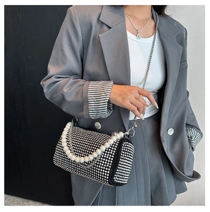 Detail of Boston bag with sparkling rhinestones and elegant pearl chain handle worn by model
