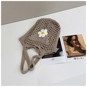 Vue détaillée d'un sac cabas tissé à la main avec une application florale de marguerite