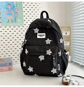 Detail of black quilted star backpack with adjustable side drawstring and star patterns