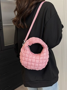 Pink quilted crossbody cloud bag with minimalist crescent shape and adjustable strap
