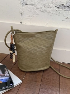 Fashionable olive green woven bucket bag with long shoulder strap and beaded ornament