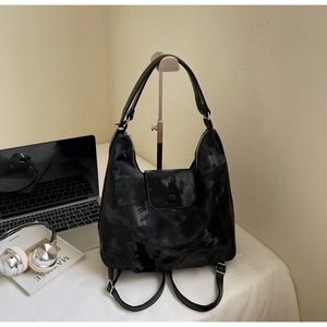 Detail of black marble textured tote backpack featuring magnetic flap and silver hardware