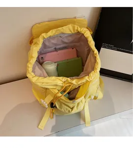 Détail intérieur du sac à dos jaune vif montrant sa grande capacité et son cordon de serrage