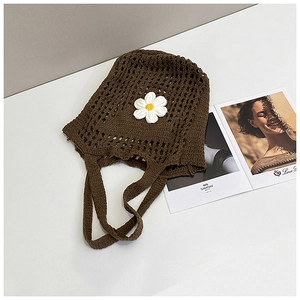 Détail du sac cabas au crochet marron avec fleur de marguerite et larges anses tissées