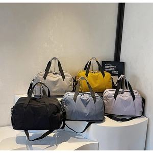 Multi-colored travel duffel bags with adjustable straps on minimalist display pedestals