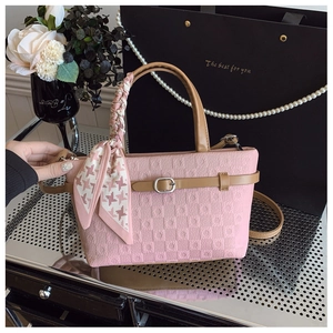 Vue détaillée d'un sac seau rose gaufré avec poignée en soie et accents de perles