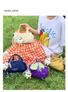 Outdoor shot of four colorful minimalist nylon crossbody bags with plush charms on grass