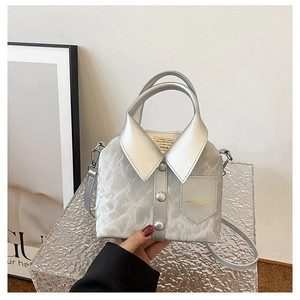 Detail of silver shirt-shaped handbag with collar, buttons and crinkled texture detail